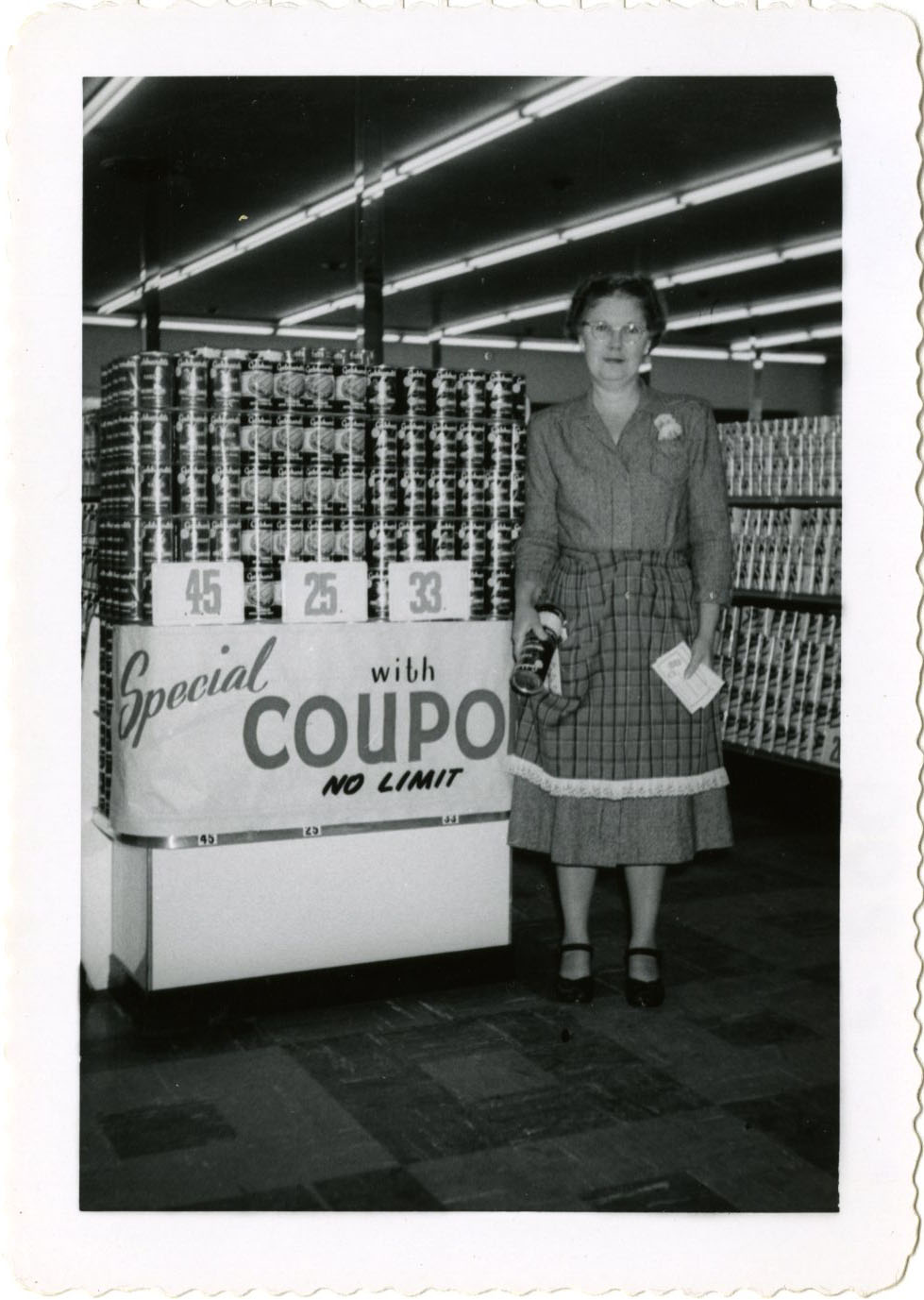Female standing beside coupon sign and store display